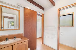 a bathroom with a sink and a mirror at Goodall Crib - Wanaka Holiday Home in Wanaka