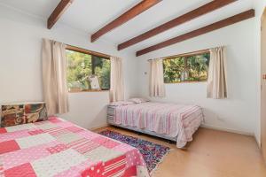 a bedroom with two beds and two windows at Goodall Crib - Wanaka Holiday Home in Wanaka
