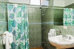 Un baño con lavabo y cortina de ducha. en The Palms At Coco Beach, en Coco