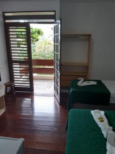 Habitación con 2 camas y puerta abierta en Pousada Portal do Cabo en João Pessoa