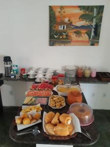 una mesa con muchos tipos diferentes de comida en ella en Pousada Portal do Cabo en João Pessoa