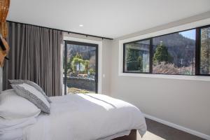 a bedroom with a bed and a large window at New Arrowtown Home, Complete comfort in Arrowtown