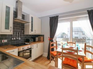 a kitchen and dining room with a table and chairs at Corvette in Trearddur