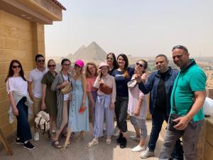 a group of people posing for a picture in front of the pyramids at Gardenia Pyramids view inn in Cairo