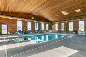 Comfort Inn Worland Hwy 16 to Yellowstone في Worland: مسبح كبير وكراسي زرقاء في مبنى