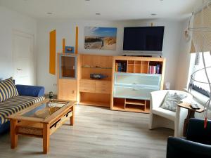 ein Wohnzimmer mit einem Sofa und einem TV in der Unterkunft Nordsee in Wilhelmshaven