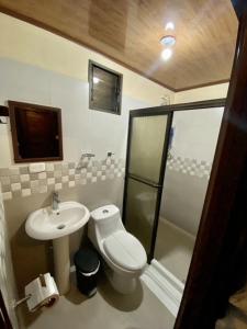 a small bathroom with a toilet and a sink at Termales del Arenal in Fortuna