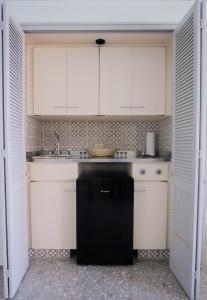 cocina con armarios blancos y lavavajillas negro en Suite frente al mar en el corazón de Acapulco en Acapulco