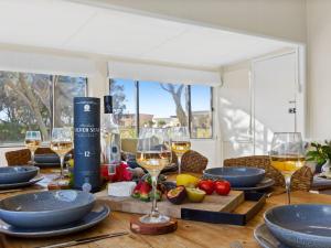 una mesa con copas de vino y comida. en Between 2 Beaches, en Culburra Beach