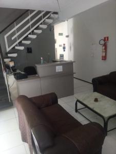 a living room with a couch and a staircase at Pousada Atlantico Centro - Fortaleza in Fortaleza