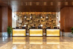 a lobby of a hotel with a stone wall at Pullman Changbaishan Resort in Fusong