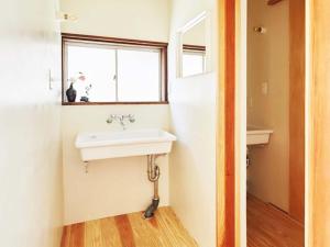 uma casa de banho com um lavatório e uma janela em Hostel & Tatami Bar Uchikobare -内子晴れ- em Uchiko