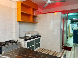 a kitchen with orange cabinets and a stove top oven at ฟ้าทะลายโจรรีสอร์ท in Prachuap Khiri Khan