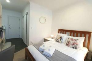 ein Schlafzimmer mit einem Bett mit Handtüchern darauf in der Unterkunft Compact City Studio In The Uni Disctrict in Auckland