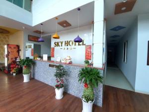 a restaurant with a counter with potted plants at Sky Hotel in Bien Hoa