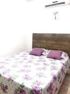 - un lit avec des oreillers violets dans une chambre dans l'établissement Aeroporto House 2, à Macapá