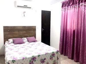 um quarto com uma cama e cortinas roxas em Aeroporto House 2 em Macapá