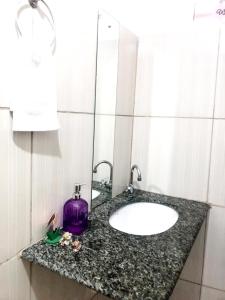 um balcão de casa de banho com um lavatório e um espelho em Aeroporto House 2 em Macapá