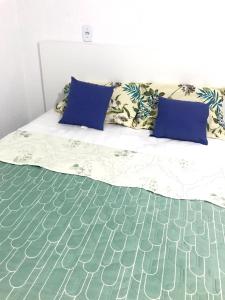 a bed with blue pillows on top of it at Aeroporto House 2 in Macapá