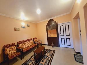 a living room with a couch and a table at IMPERIAL COTTAGE, HILL BUNK OOTY in Ooty