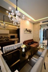 a living room with a chandelier and a dining room at Dorsett Residences Bukit Bintang @Artez Maison in Kuala Lumpur