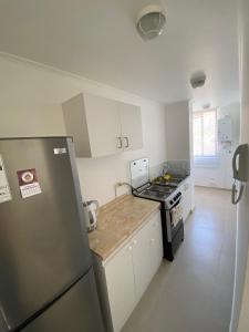 a kitchen with a refrigerator and a stove top oven at Departamento Ciudad de Caldera, Bahia Inglesa in Caldera