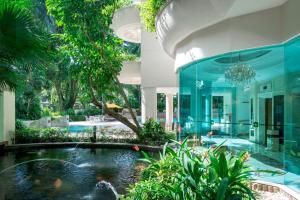 una piscina en el medio de una casa con un estanque en Shangri-La Apartments, en Singapur