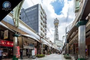 une rue de la ville avec une tour en arrière-plan dans l'établissement @RLiS_house通天閣, à Osaka