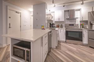 duża kuchnia z białymi szafkami i blatem w obiekcie Luxurious One Bedroom Suite for a Larger Family 162 w mieście Canmore +10 zdjęć