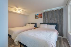 dwa łóżka w małym pokoju z oknem w obiekcie Luxurious One Bedroom Suite for a Larger Family 162 w mieście Canmore