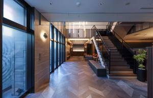 un couloir avec un escalier dans un bâtiment dans l'établissement GRIDS PREMIUM HOTEL OSAKA NAMBA, à Osaka