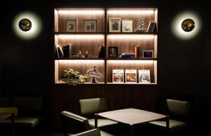 une salle à manger avec une table et une étagère avec des livres dans l'établissement GRIDS PREMIUM HOTEL OSAKA NAMBA, à Osaka