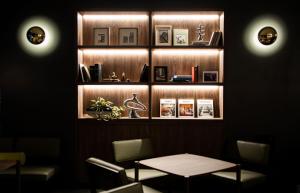 a dining room with a table and a shelf with books at GRIDS PREMIUM HOTEL OSAKA NAMBA in Osaka