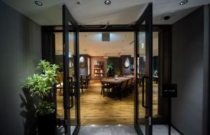 a dining room with a table and some plants at GRIDS PREMIUM HOTEL OSAKA NAMBA in Osaka