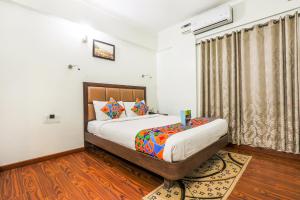 a bedroom with a large bed and a window at FabHotel Sri Krishna Suites Bellandur in Bangalore