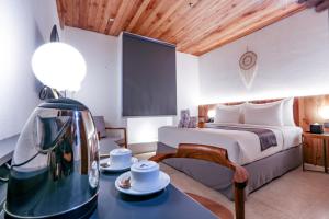 a bedroom with a bed and a table with a tea kettle at Yama Resort Indonesia in Tondano