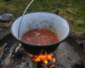 a pot of stew cooking on a fire at Brovillan in Lekeryd