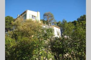 een gebouw bovenop een heuvel met bomen bij VILLA AVEC PISCINE A 400M DE LA PLAGE in Sanary-sur-Mer
