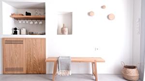 a kitchen with a wooden table and a wooden cabinet at Pénde Suites in Livadion