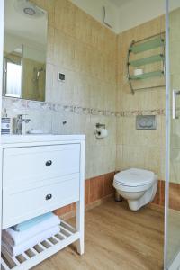łazienka z białą umywalką i toaletą w obiekcie Apartamenty Świnoujście - Apartament kapitański Rezydencja Żeromskiego w Świnoujściu