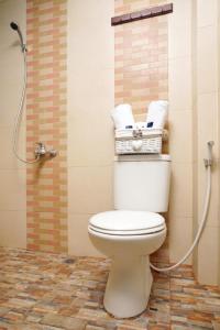 ein Badezimmer mit WC und Handtüchern darüber in der Unterkunft D'Paragon Seturan 3 in Yogyakarta