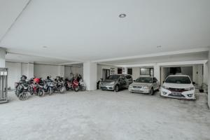 eine Gruppe von Autos und Motorrädern, die in einer Garage geparkt sind in der Unterkunft D'Paragon Seturan 3 in Yogyakarta