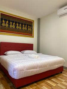 een slaapkamer met een groot bed met een rood hoofdeinde bij PP Nongkhai Resort in Nong Khai