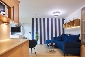 salon z niebieską kanapą i kuchnią w obiekcie Apartamenty Świnoujście - Apartament kapitański Rezydencja Żeromskiego w Świnoujściu +7 zdjęć