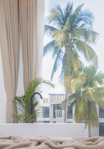 vista para uma palmeira a partir de um quarto de hotel em Xi Shan Hotel em Sanya