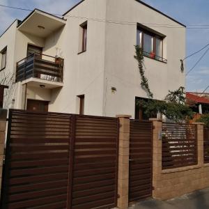 una casa con una valla de madera delante de ella en Villa 38 Silviu Apartment, en Bucarest