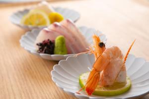 a plate of food with a shrimp on a lemon slice at Yufuin Bath Satoyamasafu in Yufu