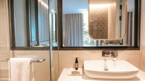 a bathroom with a sink and a mirror at The Quarter Ploenchit by UHG - SHA Extra Plus in Bangkok