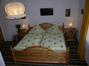um quarto com uma cama de madeira e almofadas verdes em Gästehaus Schwaiger em Schönau am Königssee