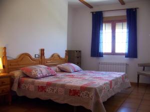 - une chambre avec un lit, une couverture et une fenêtre dans l'établissement Apartamentos La Iruela 2, à La Iruela